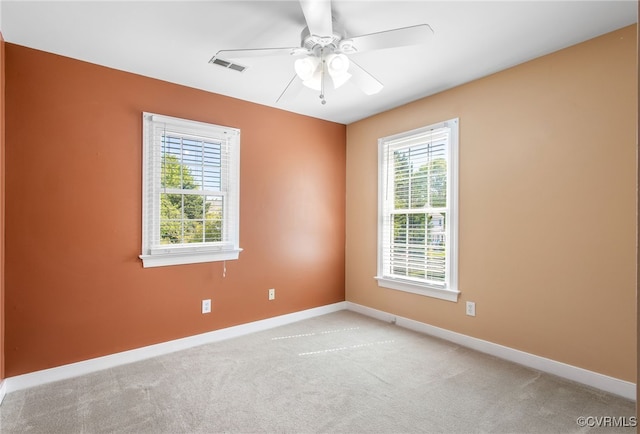 unfurnished room featuring a ceiling fan, baseboards, visible vents, and light carpet