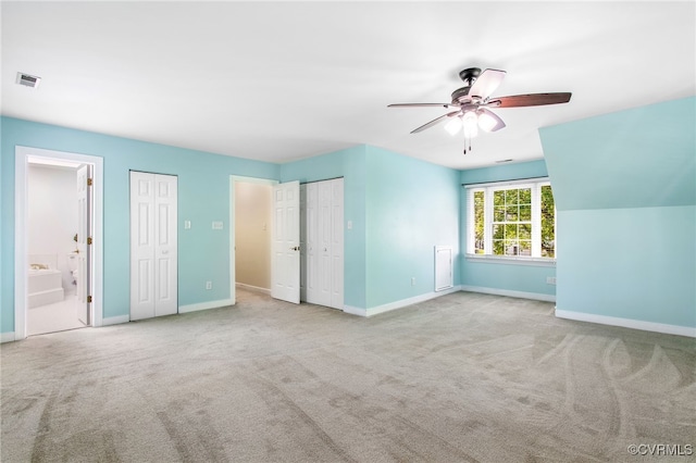unfurnished bedroom with visible vents, carpet, multiple closets, and baseboards
