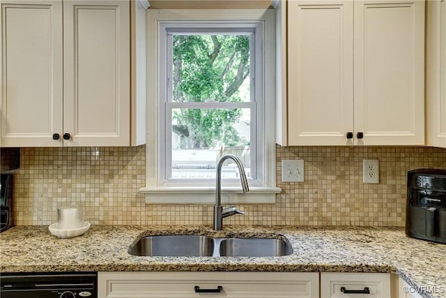 kitchen with a sink, dishwasher, white cabinetry, and backsplash