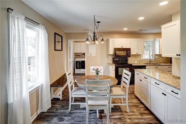 kitchen with black appliances, a sink, washer / clothes dryer, backsplash, and white cabinets