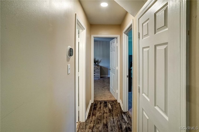 hallway with baseboards, dark wood finished floors, and recessed lighting