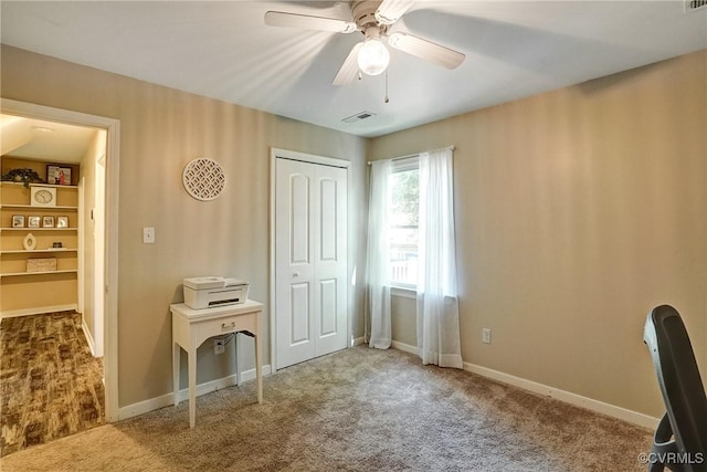 unfurnished office featuring carpet, ceiling fan, and baseboards