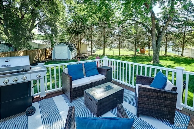 wooden deck featuring an outdoor living space, a storage unit, an outbuilding, and area for grilling