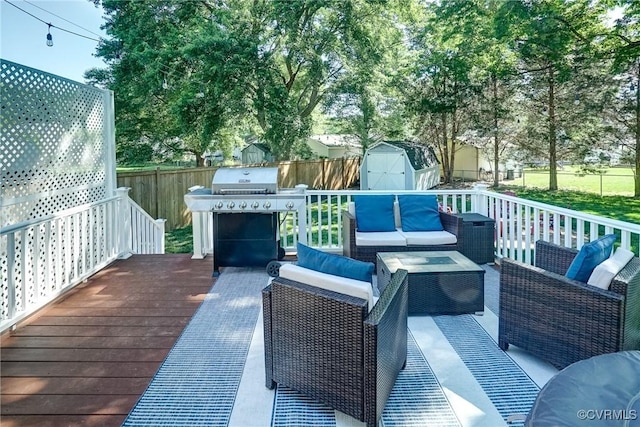 wooden deck with an outdoor hangout area, a grill, a shed, and a fenced backyard