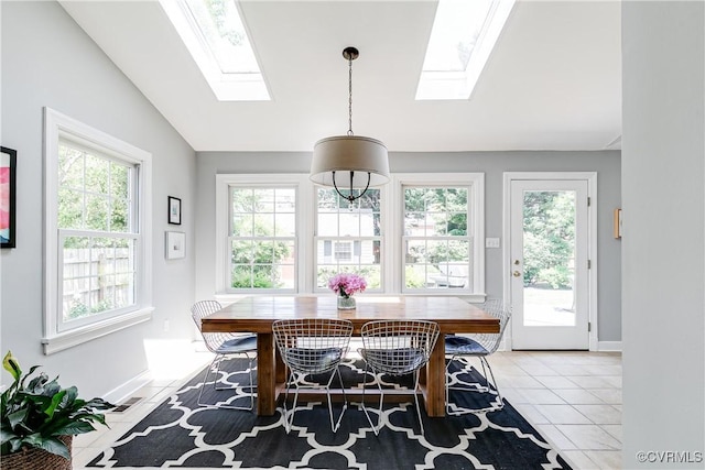 dining room with baseboards, light tile patterned floors, a wealth of natural light, and a skylight