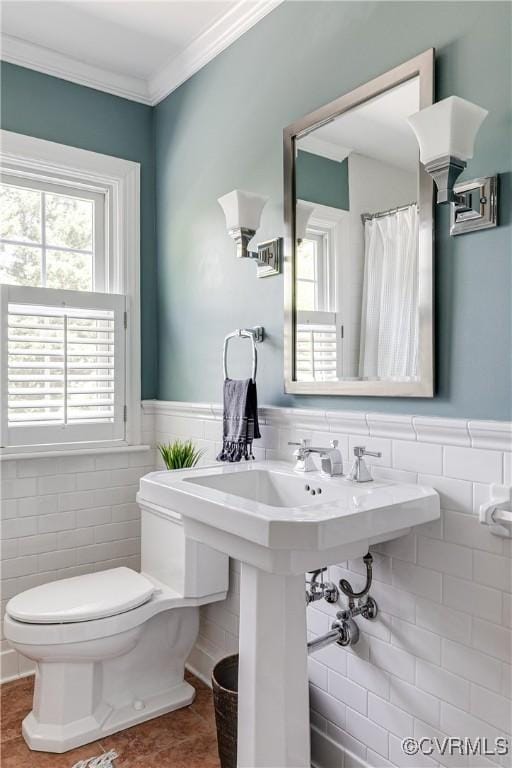 full bath featuring wainscoting, toilet, tile walls, and ornamental molding