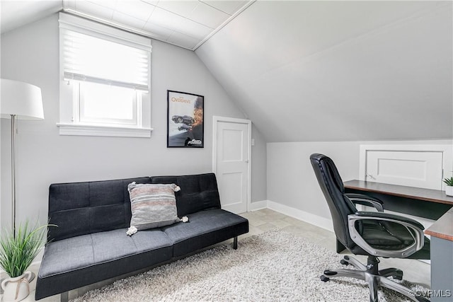 tiled office space featuring vaulted ceiling