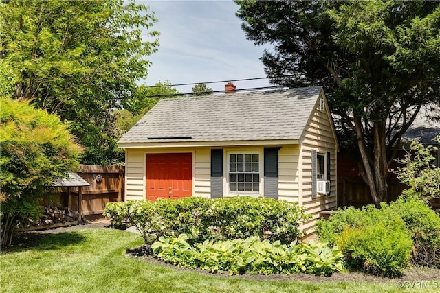 view of outdoor structure with fence and an outbuilding