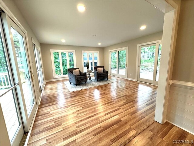 sitting room featuring plenty of natural light, light wood-type flooring, recessed lighting, and baseboards