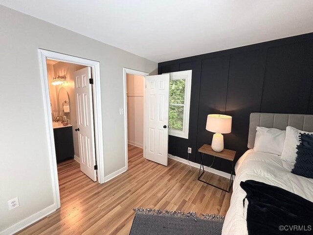 bedroom with light wood-type flooring and baseboards