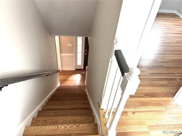 stairway featuring wood finished floors and baseboards