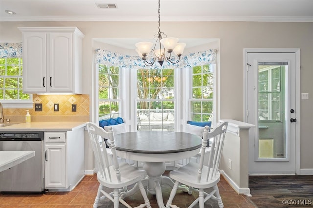 dining space with crown molding, baseboards, an inviting chandelier, and visible vents