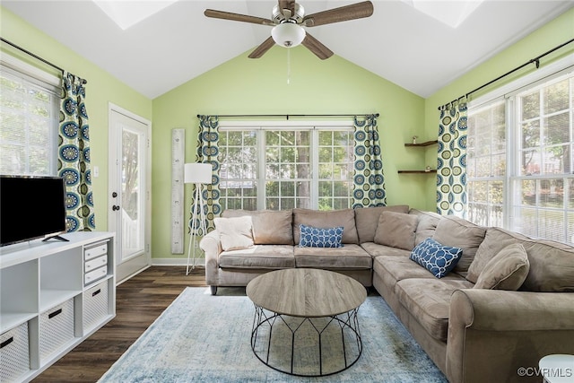 living room featuring dark wood finished floors, lofted ceiling with skylight, and a wealth of natural light