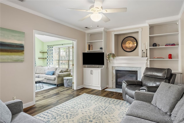 living area with crown molding, a ceiling fan, dark wood-style flooring, and baseboards