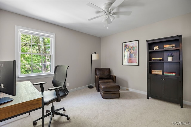 office space with a ceiling fan, baseboards, and light colored carpet