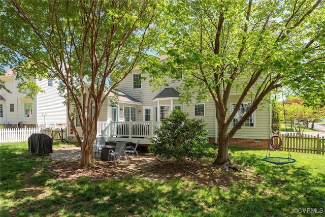 rear view of house featuring fence, a lawn, a deck, and crawl space