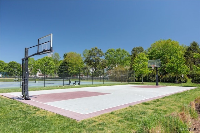 view of sport court featuring a lawn, community basketball court, and a tennis court