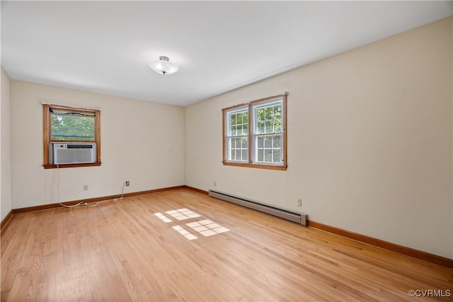 unfurnished room featuring baseboards, cooling unit, a baseboard heating unit, and light wood-style flooring