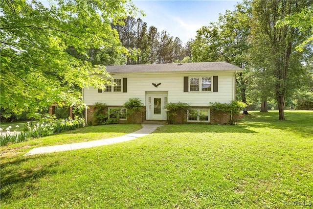 bi-level home featuring brick siding and a front lawn