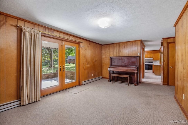 living area featuring french doors, a textured ceiling, light carpet, and baseboard heating