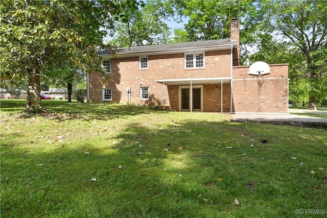 rear view of property with a lawn, brick siding, and a chimney
