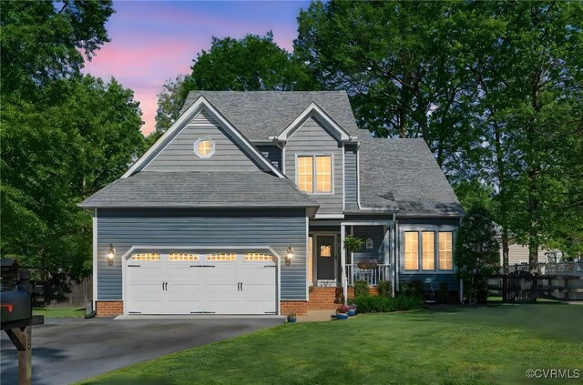 craftsman inspired home with a garage, fence, a shingled roof, a lawn, and driveway