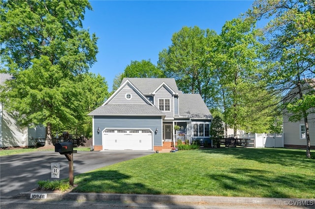 view of front of property with a front lawn, aphalt driveway, fence, a shingled roof, and an attached garage