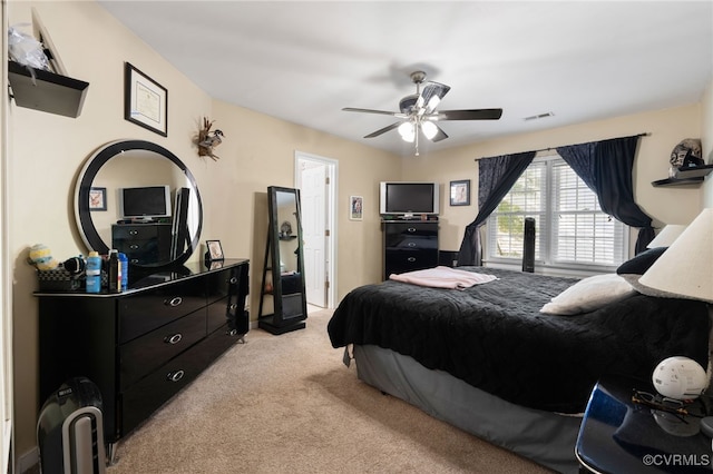 bedroom featuring a ceiling fan, light colored carpet, and visible vents