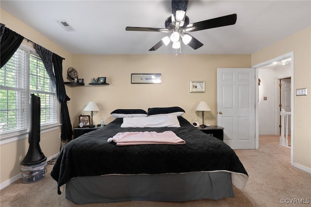 carpeted bedroom featuring baseboards, a ceiling fan, and visible vents
