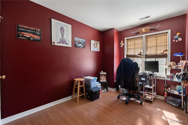 office featuring baseboards, visible vents, and wood finished floors