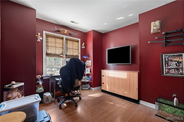 home office featuring baseboards, wood finished floors, and visible vents