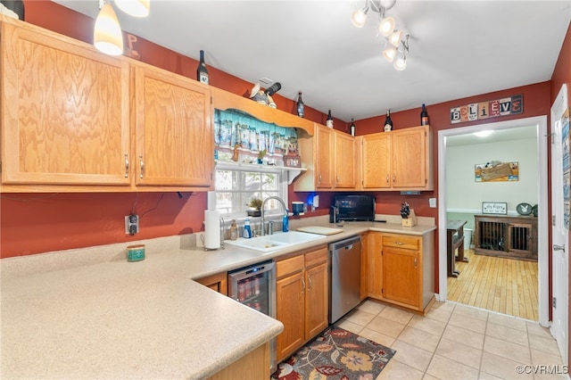 kitchen featuring stainless steel dishwasher, light countertops, a sink, and wine cooler