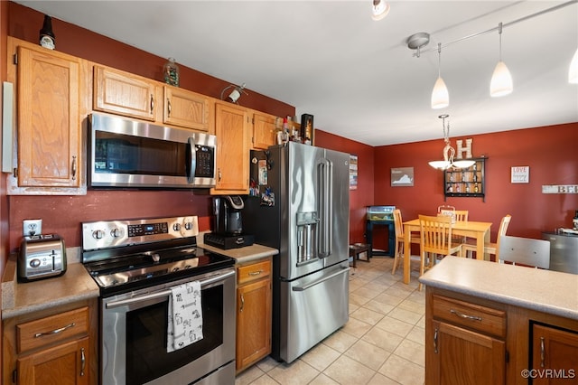 kitchen featuring light countertops, pendant lighting, light tile patterned floors, and stainless steel appliances