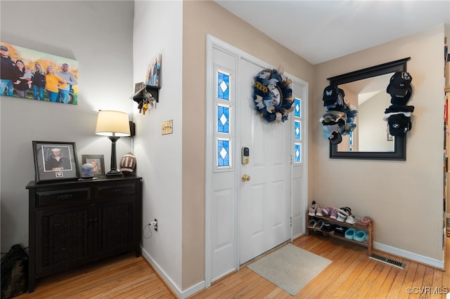 entryway featuring baseboards, visible vents, and hardwood / wood-style flooring