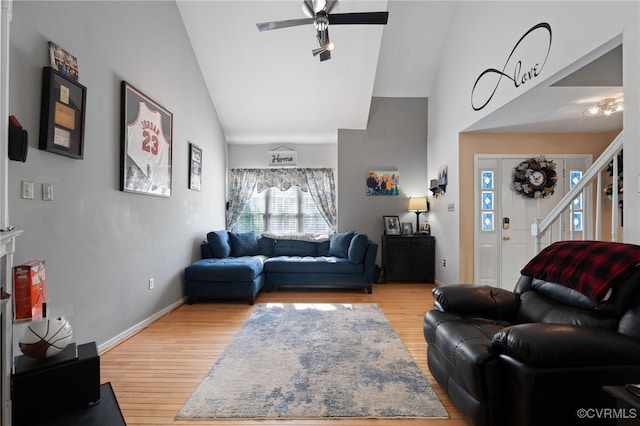living room with ceiling fan, baseboards, high vaulted ceiling, and light wood-style floors