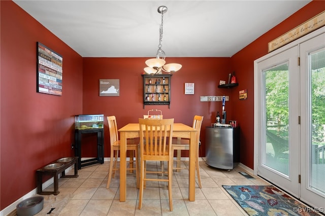 dining room with a notable chandelier, water heater, baseboards, light tile patterned floors, and visible vents