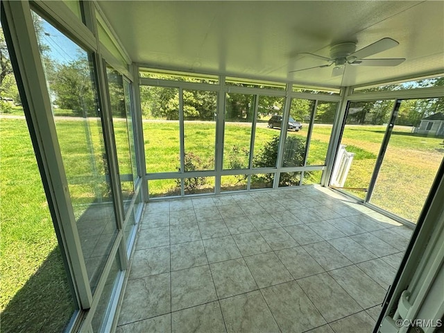unfurnished sunroom featuring a ceiling fan