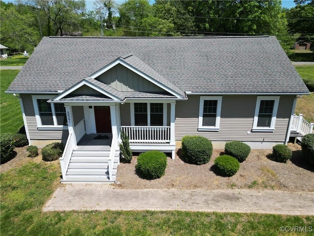 view of front of property featuring a porch, board and batten siding, roof with shingles, and stairs