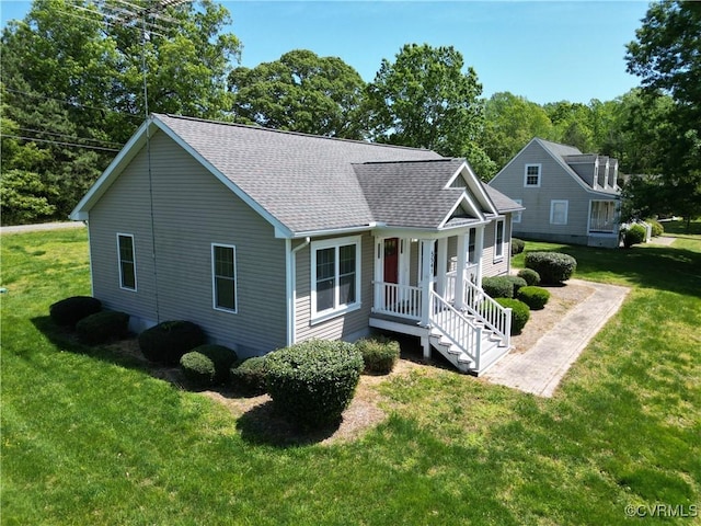 view of front of home with a shingled roof and a front yard