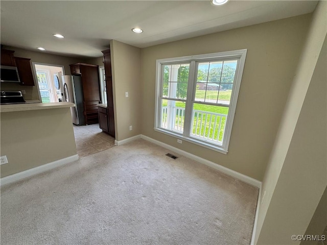 interior space with baseboards, recessed lighting, a healthy amount of sunlight, and light carpet
