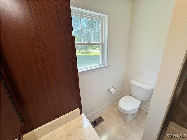 bathroom with baseboards, visible vents, and toilet