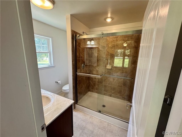 bathroom featuring vanity, tile patterned floors, a stall shower, and toilet