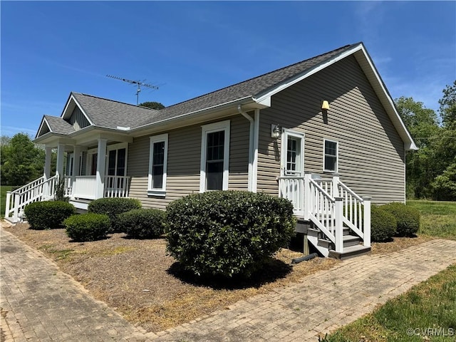 view of home's exterior with a porch and roof with shingles