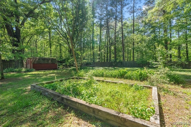 view of yard with an outbuilding, a garden, a fenced backyard, and a storage unit