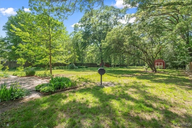 view of yard featuring a storage unit, a fenced backyard, and an outbuilding