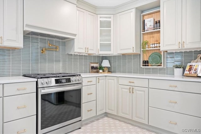 kitchen with light countertops, white cabinets, gas stove, and tasteful backsplash