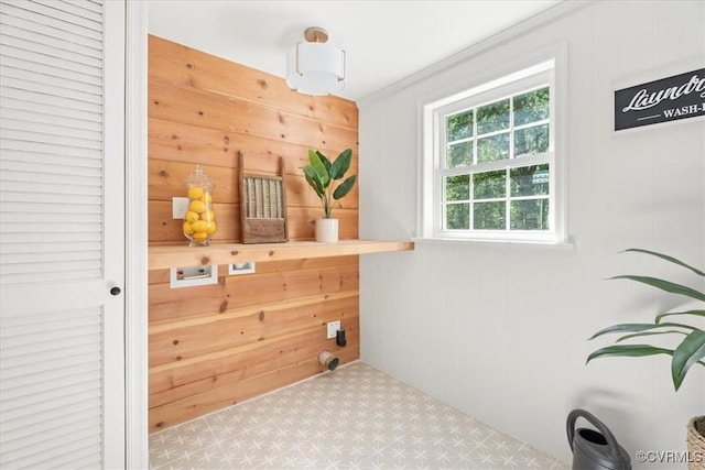 clothes washing area with laundry area, wood walls, tile patterned floors, and hookup for a washing machine