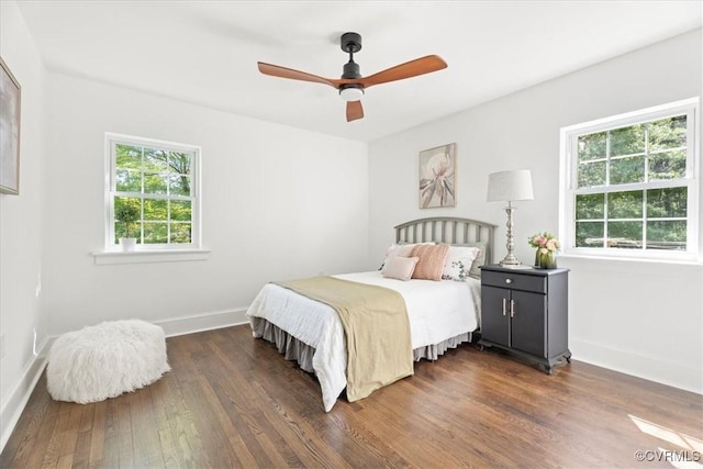 bedroom featuring baseboards, ceiling fan, and dark wood-style flooring