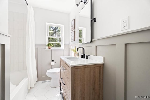 bathroom featuring wainscoting, tile patterned flooring, vanity, toilet, and shower / bath combination with curtain