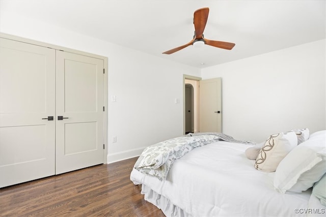 bedroom with ceiling fan, dark wood finished floors, baseboards, and a closet